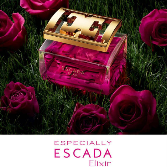 Escada perfume bottle with gold cap surrounded by pink roses on grass