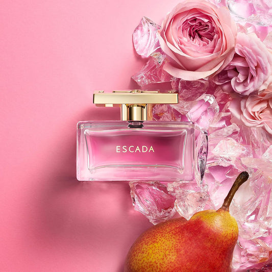 Escada perfume bottle with pink roses and a pear on a pink background